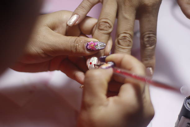 Beautiful female hand with pink nail polish manicure and ring.