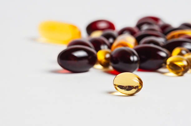 istock Vibrant capsules and pills sit on a white background, showcasing health supplements. 2222730740