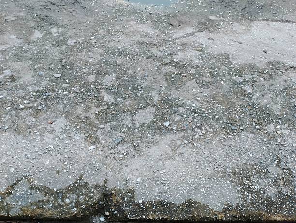istock Wet Concrete Surface with Small Pebbles and Water Puddles Texture 2222732590