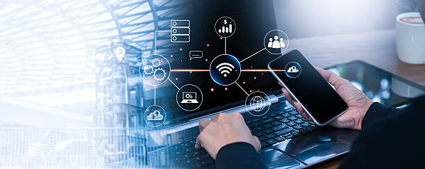 istock Businessman Hand Using Smartphone and Laptop with Technology Icon Overlay, Digital Connection Concept for Innovation, Cloud Computing, Wireless Network, and Modern Communication Background 2222741012