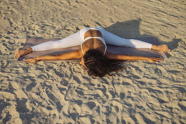istock Woman practicing yoga pose outdoors on sandy beach during sunrise 2222744395