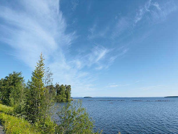 istock A beautiful landscape features a tranquil lake under a bright blue sky with soft clouds. 2222747924