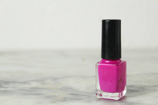 pink nail polish bottle jar with black cap on white background.