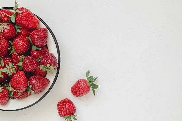 istock Fresh red strawberries in a a round plate on a white background. Top view. Copy space. 2222749448