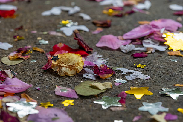 Colorful confetti and flower petals scattered on the ground after a joyful celebration in a vibrant community setting stock photo