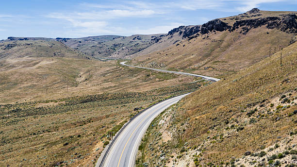 istock Snaking asphalt road through rugged terrain. Empty highway winds across Owyhee County hills in Idaho. 2222751541
