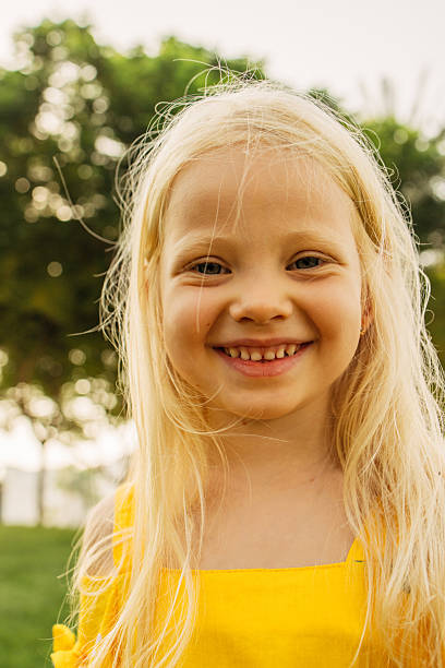 istock Smiling child outdoors wearing yellow dress during a sunny spring afternoon 2222752021