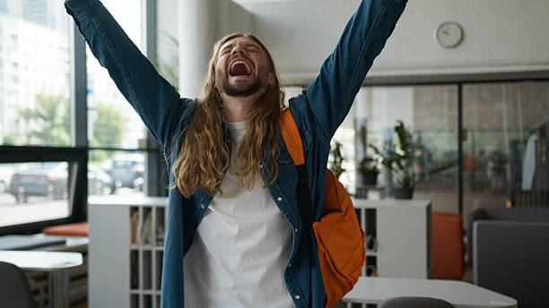 istock Caucasian student guy man male win mobile phone raised hands champion winner joyful winning successful triumph lucky smartphone yelling in university online bet rejoice emotive victory in college 2222752821