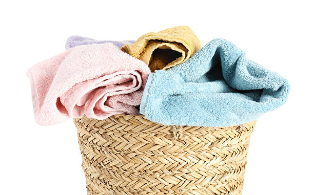 istock Laundry basket full of towels isolated on white 2222754706
