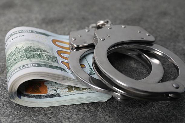 istock Corruption concept. Handcuffs and dollar banknotes on grey table, closeup 2222754986