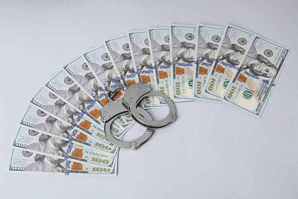 istock Corruption concept. Handcuffs and dollar banknotes on grey background 2222755001