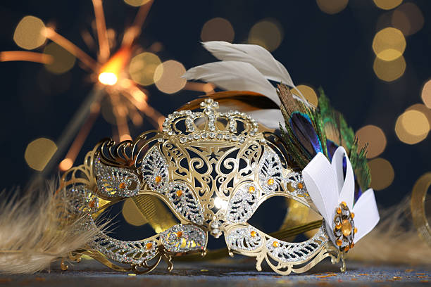 istock Beautiful carnival mask and confetti on table against dark background with blurred lights, closeup 2222755681