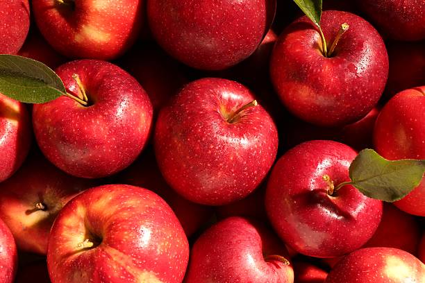 istock Fresh ripe red apples and green leaves as background, top view 2222755765