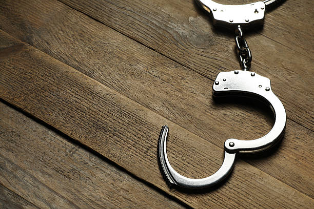 istock Classic chain handcuffs on wooden table, closeup. Space for text 2222756201