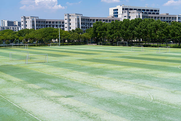 University campus football field under blue sky and white clouds