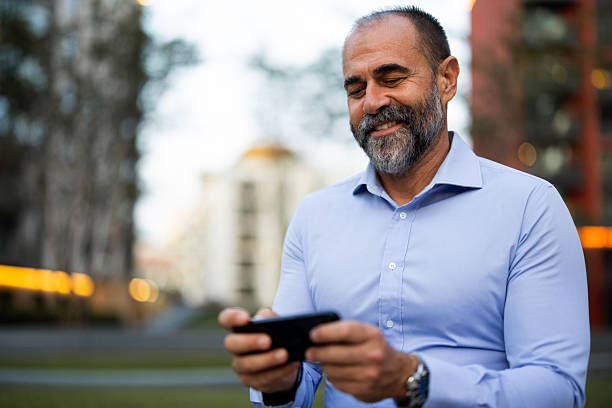 istock Smiling mature businessman using smartphone in urban setting 2222757866