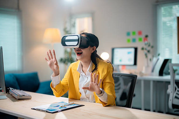 istock Businesswoman wearing a virtual reality headset is immersed in the metaverse while working in a sleek, modern office environment 2222763777