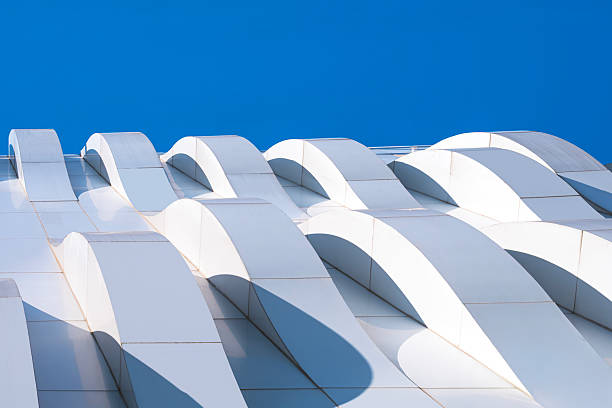 istock Curve 3d dimension pattern of geometric white aluminum composite tile wall of modern building against blue sky background, View from below 2222765513