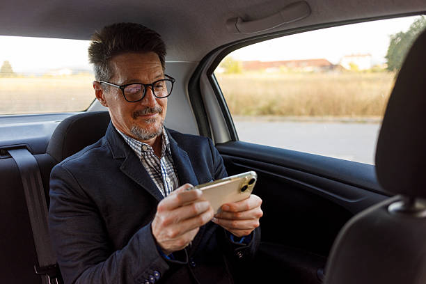 istock Man with Glasses Playing Mobile Gaming in Car Backseat 2222768628