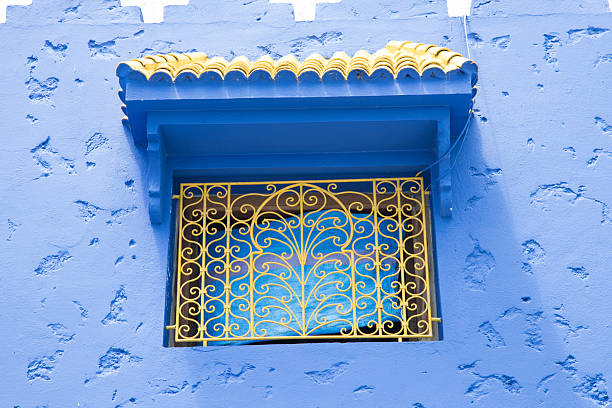 Small window with carved grille and canopy in Mediterranean style. Characteristic architectural detail typical of the Mediterranean climate.