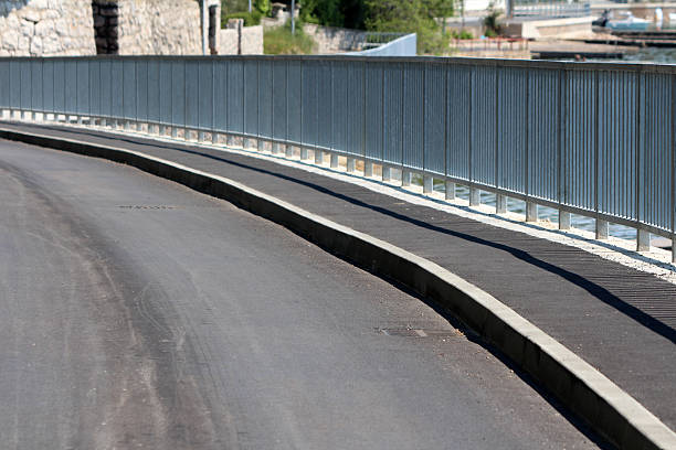 istock Curved asphalt road with metal railing along waterfront promenade 2222773971