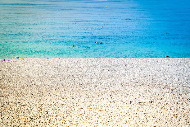 stone beach and turquiose water of cote dAzur at Nice at summer, Riviera, France