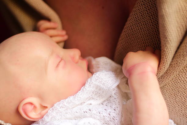 The tiny hands of a newborn baby held in the mother's hands with love and warmth.