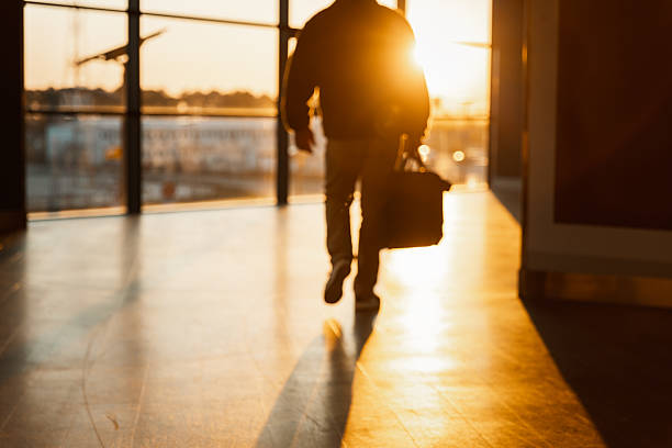 istock Man Walking Through Airport at Golden Hour 2222780258