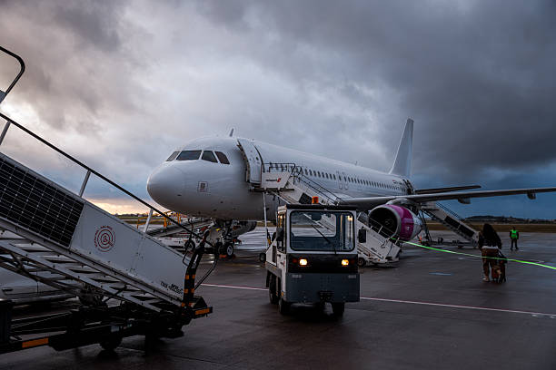 istock Passengers Boarding Plane on Tarmac at Sunset 2222780822