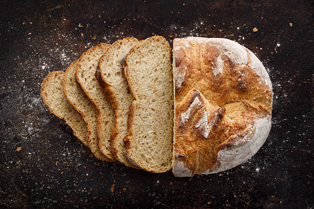Crispy sliced loaf of bread with flour