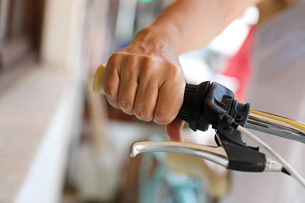 Close-up of a woman’s hand gripping the handlebar of a retro-style bicycle. The image evokes themes of sustainable transportation, freedom, summer lifestyle, and active living.