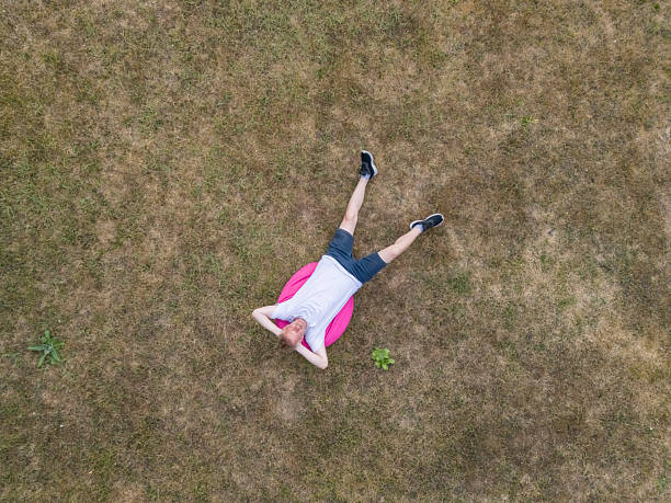 Young man trimming fresh grass with trimmer