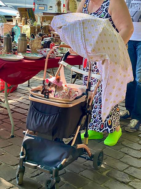 Turnhout, Belgium ~ June 29,  2025.  Couple walking with there Pussycat in  a baby carriage on the vintage Market.