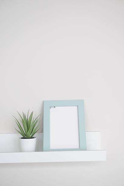 istock Simple decor with a plant and a blank picture frame on a shelf 2222790029