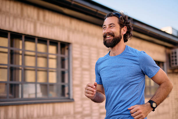 Happy bearded man running outdoors in the city