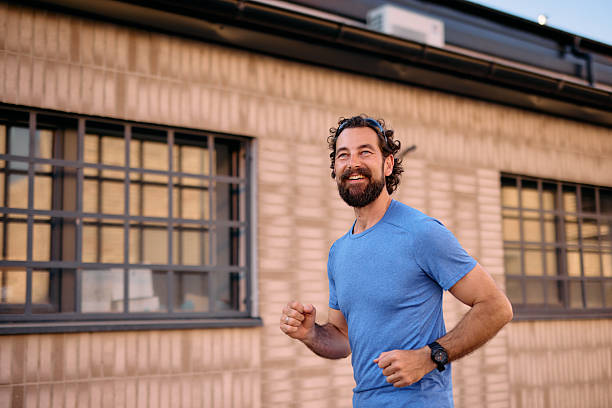istock Mid adult man running outside and smiling 2222793965