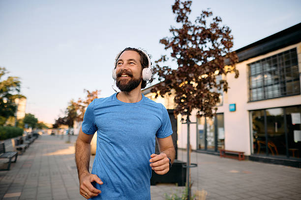 istock Man jogging outdoors while listening music with headphones 2222794376