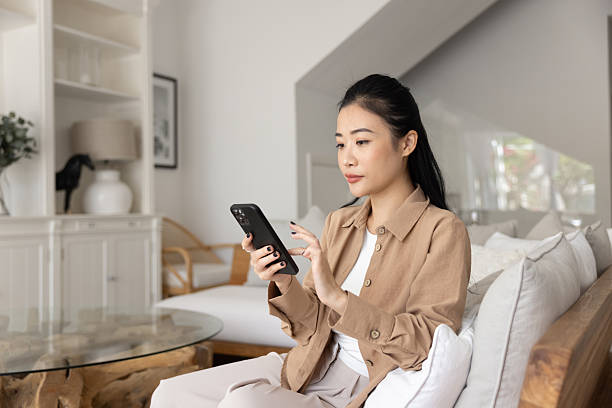 istock Focused beautiful young adult Asian girl using smart home application 2222797559