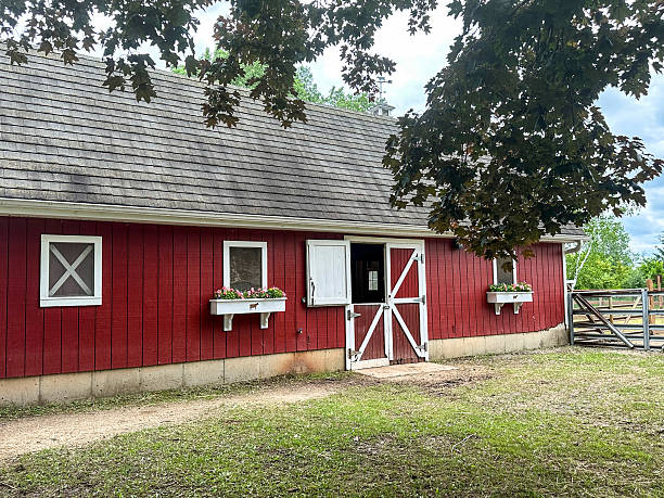 istock Small red wood barn building with flowers in window boxes 2222801407