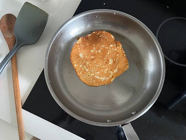 A stainless steel pan with a pancake sitting on it cooking