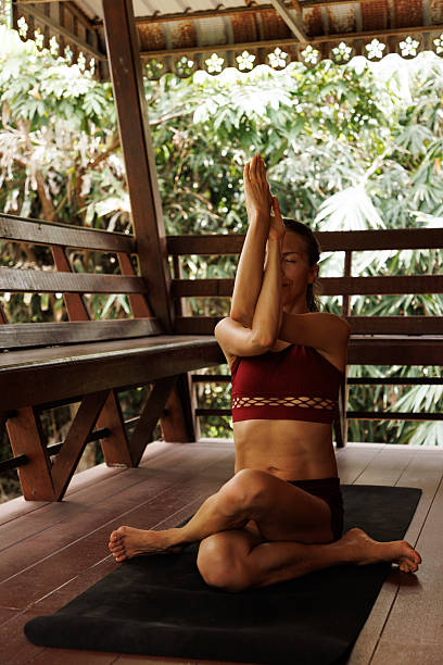 istock Woman practicing yoga on a veranda surrounded by lush greenery and natural light 2222805781