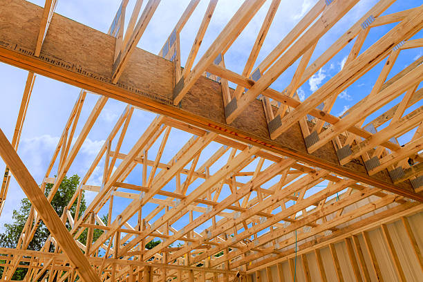 istock Construction of wooden trusses framework under bright blue sky at residential building site 2222806513