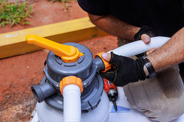 istock Hands connect hose to pump system cleaner attachment while working outdoors in pool 2222806518