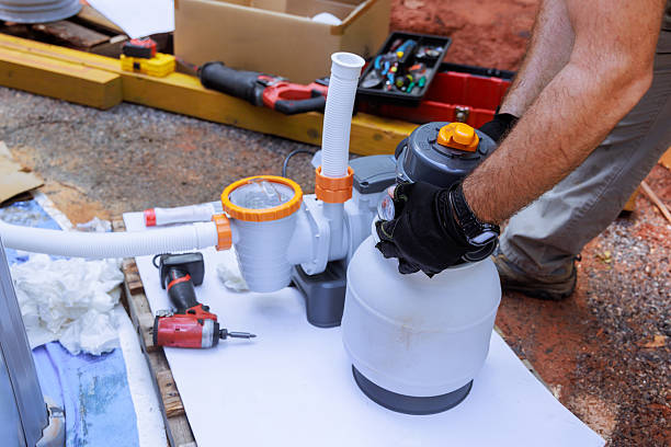 istock Hands working on pool filter system installation at residential backyard during works day 2222806520