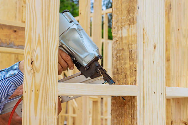 istock Skilled worker using nail gun to secure wooden beams at construction site 2222806538