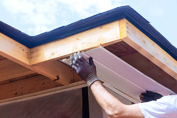 istock Worker installs soffit panels under eaves at residential home during works day 2222806574