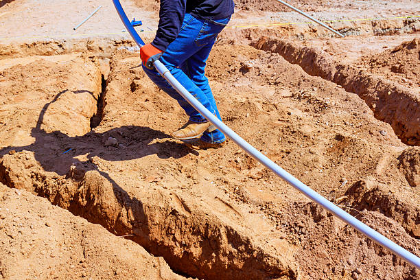 istock Caucasian man laying electrical pvc pipe in trench at construction site 2222806581