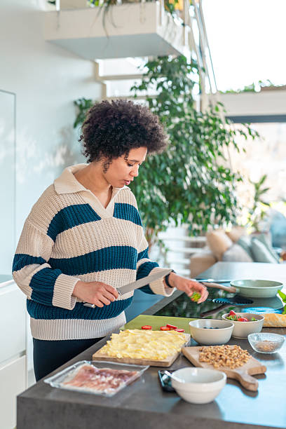 istock Mixed Race Woman Creating Butter Board in Cozy Kitchen 2222806842