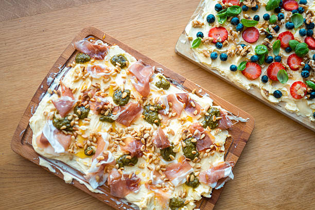 A homemade butter board featuring creamy butter topped with fresh strawberries, blueberries, nuts, and herbs. Perfect for a delightful and tasty appetizer at any gathering.