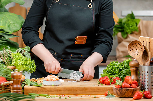 istock chef skillfully chopping onion, vegetables and arranging fresh ingredients on a cutting board in a vibrant kitchen setting. 2222814113
